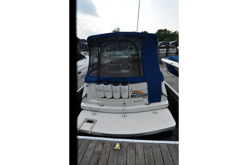 Slide: The Image of 2002 Rinker Fiesta Vee 310 boat docked with blue canopy and fenders. - 26