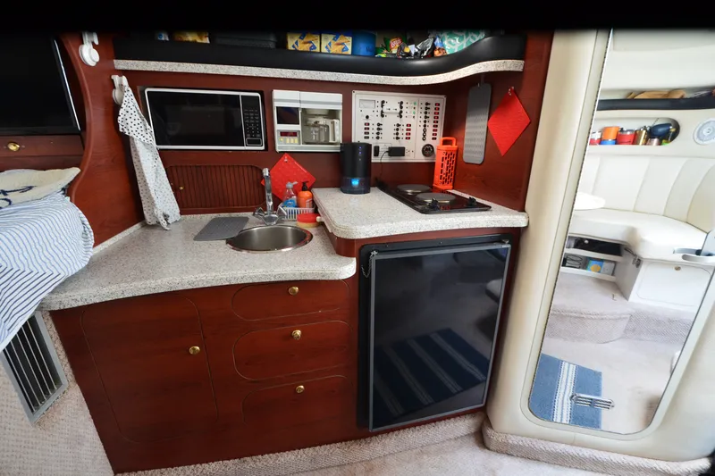 Slide: The Image of 2002 Rinker Fiesta Vee 310 boat interior with kitchenette, sink, and appliances. - 23