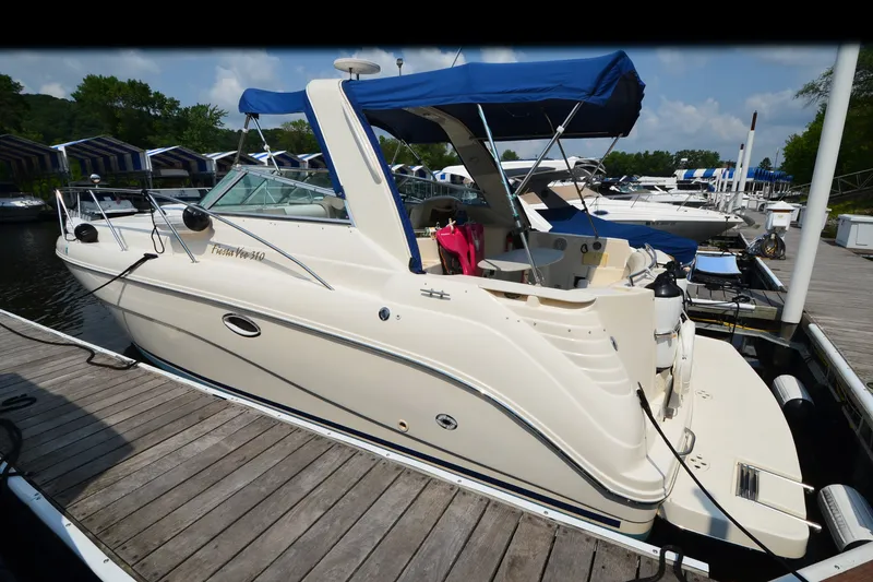 Slide: The Image of 2002 Rinker Fiesta Vee 310 boat docked at marina with blue canopy. - 27