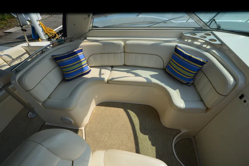 Slide: The Image of 2002 Rinker Fiesta Vee 310 boat interior with cushioned seating and striped pillows. - 14