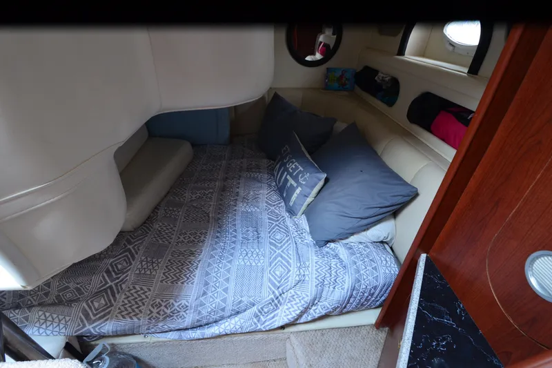 Slide: The Image of Cozy cabin interior of 2002 Rinker Fiesta Vee 310 with patterned bedding and pillows. - 25