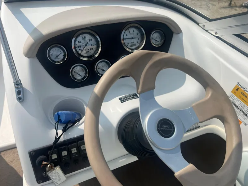Slide: The Image of The image shows the dashboard of a 2002 Chaparral 180 SSe boat with multiple gauges and a steering wheel. - 16