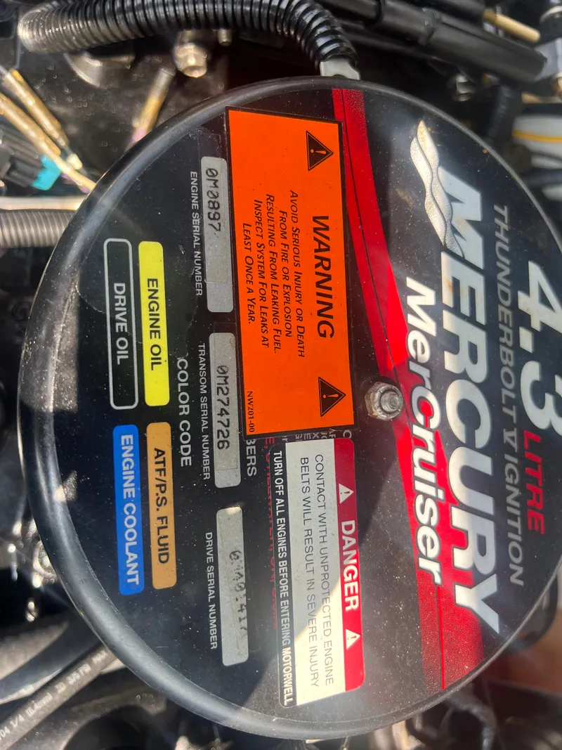 Slide: The Image of Close-up of a Mercury MerCruiser engine with warning labels and fluid information. - 23