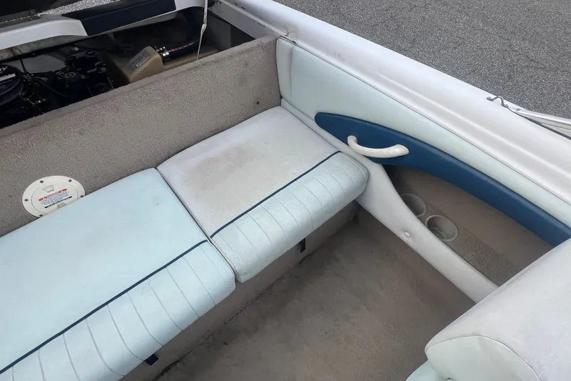 Slide: The Image of Interior of a 2002 Chaparral 180 SSe boat, featuring cushioned seating and cup holders. - 47