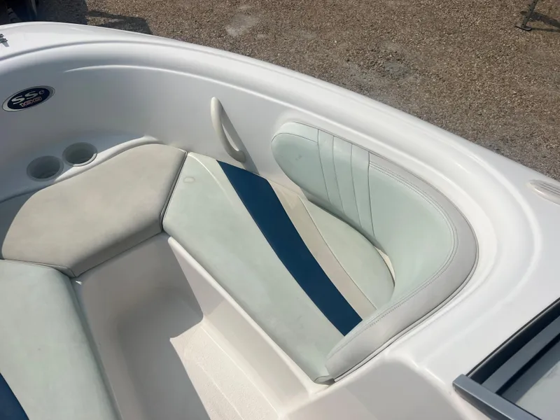 Slide: The Image of The image shows the seating area of a 2002 Chaparral 180 SSe boat with blue and gray upholstery. - 13