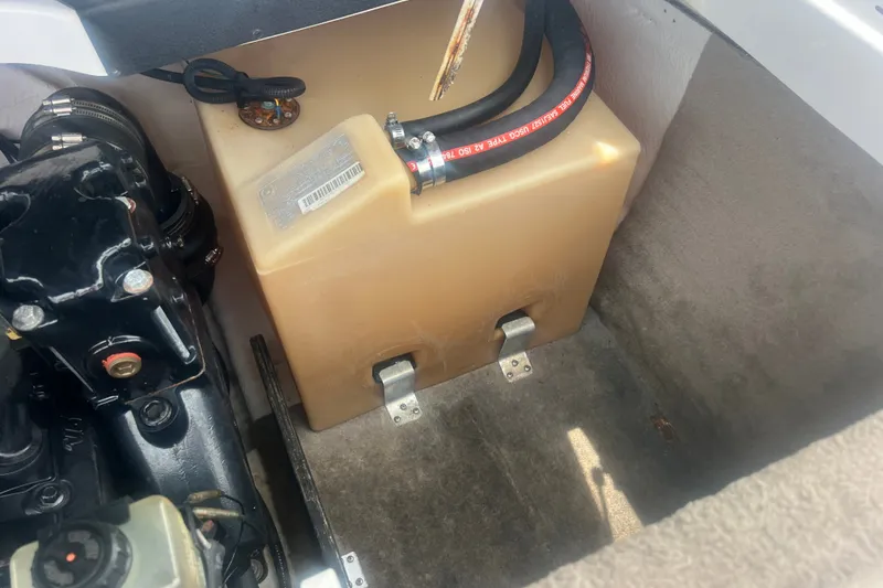 Slide: The Image of Engine compartment of a 2002 Chaparral 180 SSe boat, featuring a fuel tank and hoses. - 56