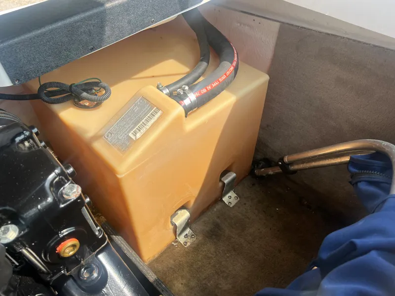 Slide: The Image of An engine compartment with a plastic tank and hoses in a 2002 Chaparral 180 SSe boat. - 24