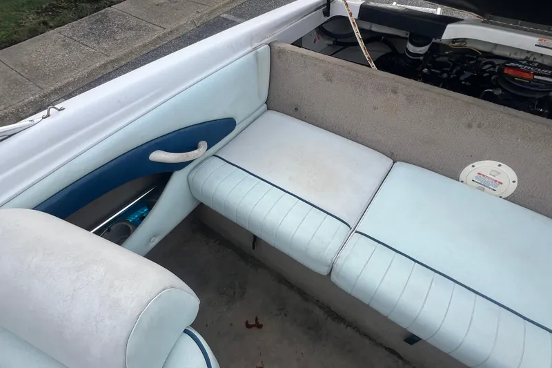 Slide: The Image of 2002 Chaparral 180 SSe boat interior with light blue seating and visible engine compartment. - 48