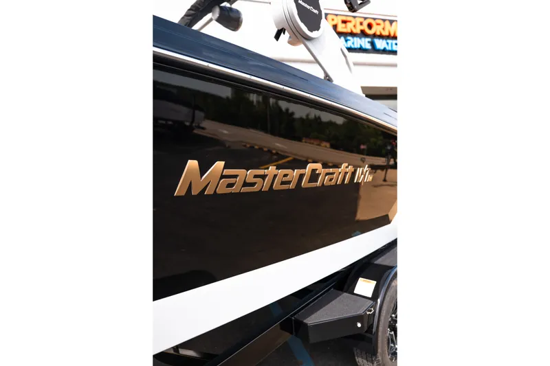 Slide: The Image of 2027 MasterCraft NXT24 boat side view with logo in a marina setting. - 16