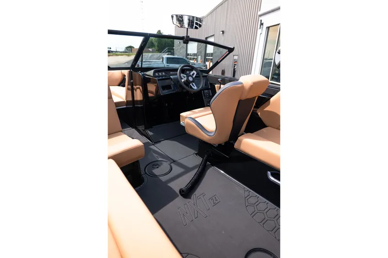 Slide: The Image of Interior of 2027 MasterCraft NXT24 boat with tan seating and modern dashboard. - 27