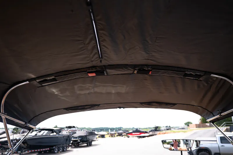 Slide: The Image of 2027 MasterCraft NXT24 boat canopy interior view at a marina. - 48