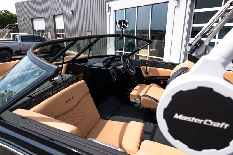 Slide: The Image of 2027 MasterCraft NXT24 boat interior with tan seats and modern dashboard design. - 17