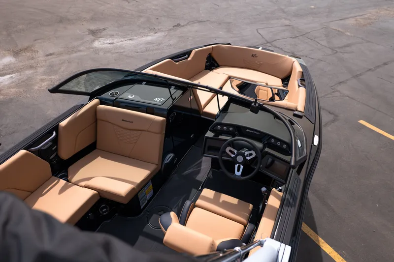 Slide: The Image of 2027 MasterCraft NXT24 boat interior with tan seating and modern dashboard design. - 21