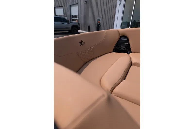 Slide: The Image of 2027 MasterCraft NXT24 boat interior with tan seating and speaker detail. - 14
