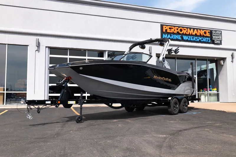 The Image of 2027 MasterCraft NXT24 boat on trailer at Performance Marine Watersports dealership. - 1