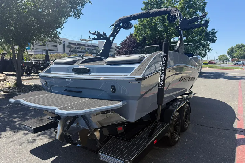 Slide: The Image of 2026 MB B52 23 Alpha boat on trailer, parked outdoors in sunny setting. - 5