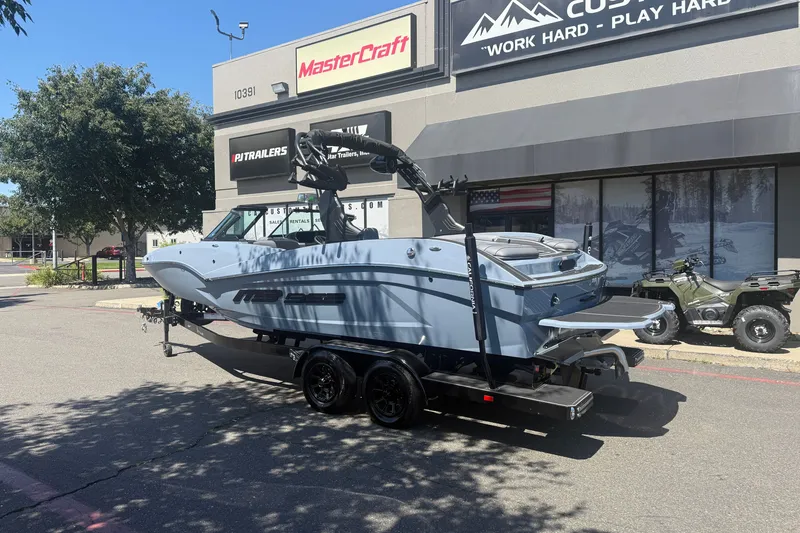 Slide: The Image of 2026 MB B52 23 Alpha boat on trailer outside dealership, sunny day. - 3