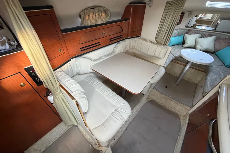 Slide: The Image of Interior of 2001 Sea Ray Sundancer 280, featuring cozy seating and elegant wood cabinetry. - 17