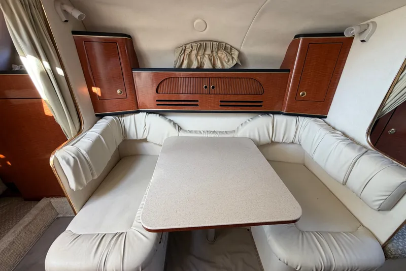 Slide: The Image of Interior of 2001 Sea Ray Sundancer 280 with cushioned seating and wooden cabinetry. - 20