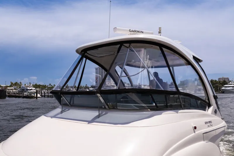 Slide: The Image of 2010 Sea Ray 52 Sedan Bridge yacht cruising in a marina under a clear blue sky. - 69