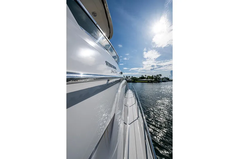 Slide: The Image of 2010 Sea Ray 520 Sedan Bridge yacht on sunny water, showcasing sleek design and reflective surface. - 31