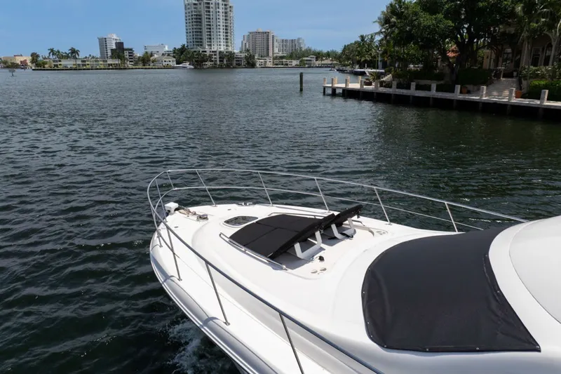 Slide: The Image of 2010 Sea Ray 52 Sedan Bridge yacht cruising near waterfront cityscape. - 32