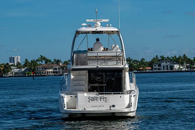 Slide: The Image of 2010 Sea Ray 520 Sedan Bridge yacht cruising on a sunny day near waterfront homes. - 12