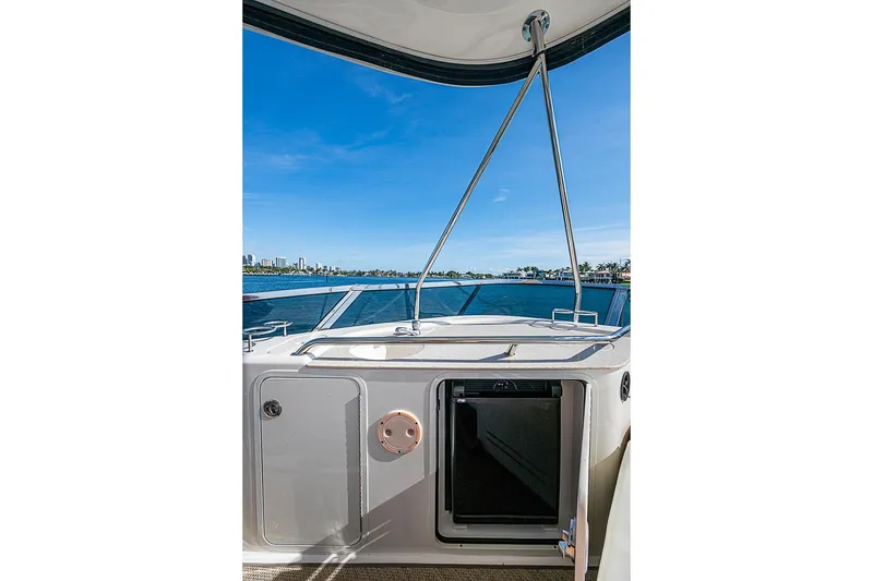 Slide: The Image of 2010 Sea Ray 520 Sedan Bridge yacht with open hatch, overlooking serene blue waters. - 17