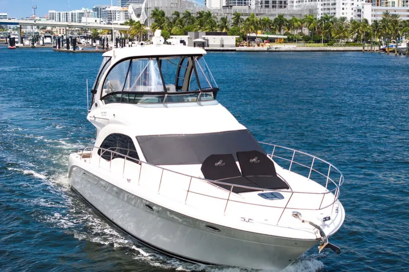 Slide: The Image of 2010 Sea Ray 52 Sedan Bridge yacht cruising in a vibrant marina setting. - 1