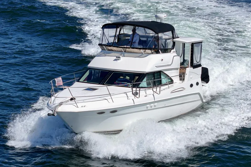 Slide: The Image of A white motor yacht speeds through the water, featuring a covered flybridge and multiple windows. - 5