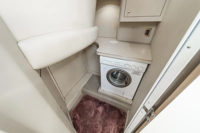 Slide: The Image of The 1999 Sea Ray 370 Aft Cabin features a laundry area with a washing machine and storage space. - 42