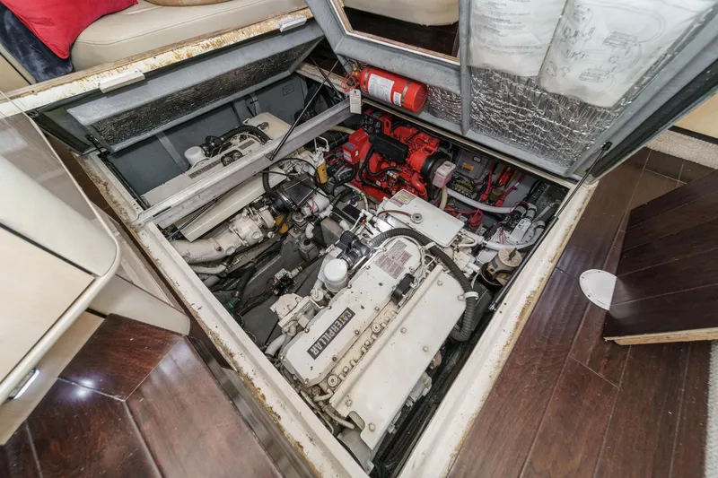 Slide: The Image of The engine compartment of a 1999 Sea Ray 370 Aft Cabin with visible engines and fire extinguisher. - 48