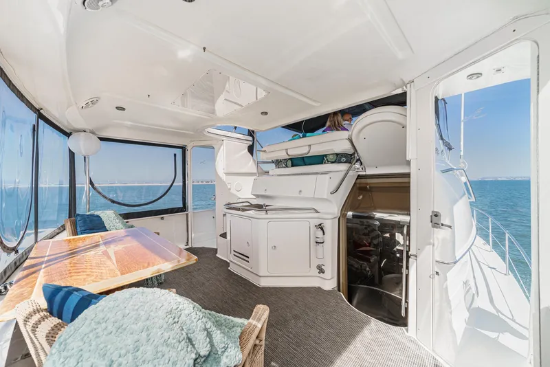 Slide: The Image of The image shows the spacious aft deck of a 1999 Sea Ray 370 Aft Cabin with table and seating. - 9