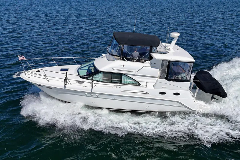 Slide: The Image of A white 1999 Sea Ray 370 Aft Cabin boat speeds across the blue water. - 7