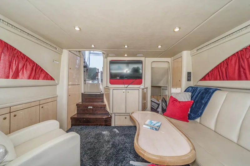 Slide: The Image of The interior of a 1999 Sea Ray 370 Aft Cabin with cozy seating and a TV. - 31
