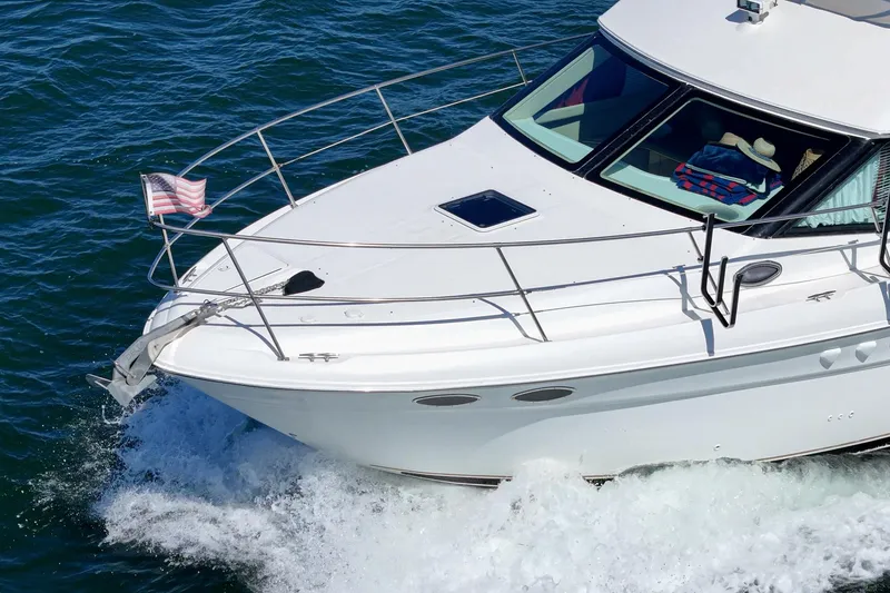 Slide: The Image of A white boat cruising through the water, with an American flag at the bow. - 18