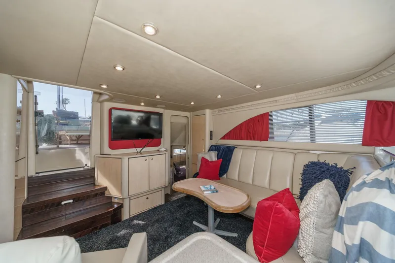Slide: The Image of The interior of a 1999 Sea Ray 370 Aft Cabin with cozy seating and a TV. - 27