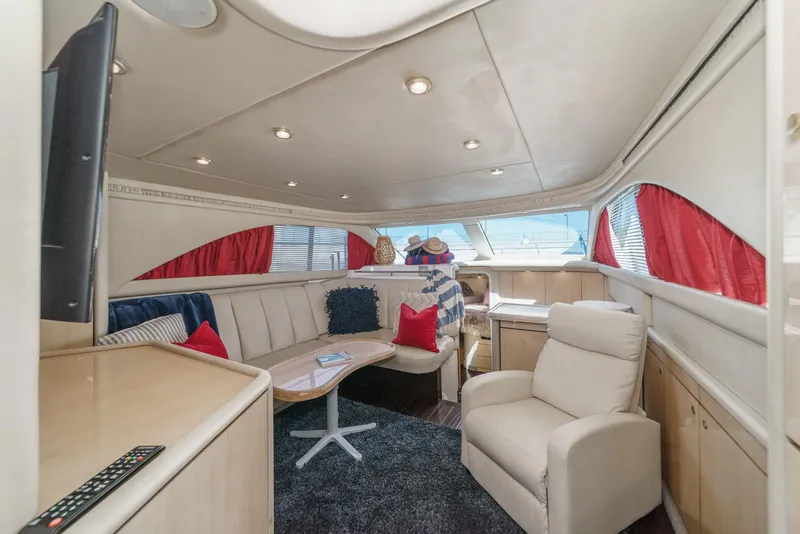 Slide: The Image of The interior of a 1999 Sea Ray 370 Aft Cabin features a cozy seating area with red accents. - 25