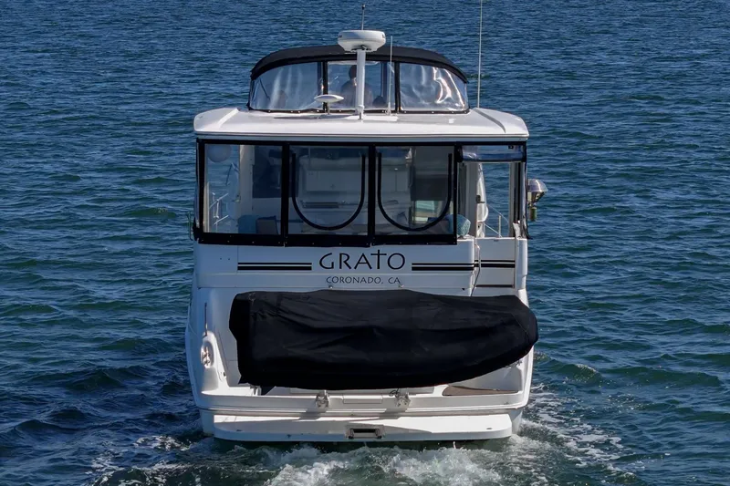 Slide: The Image of A 1999 Sea Ray 370 Aft Cabin cruising on the water. It features a covered aft deck. - 12
