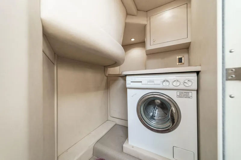 Slide: The Image of The laundry area aboard the 1999 Sea Ray 370 Aft Cabin features a washing machine in a compact space. - 41