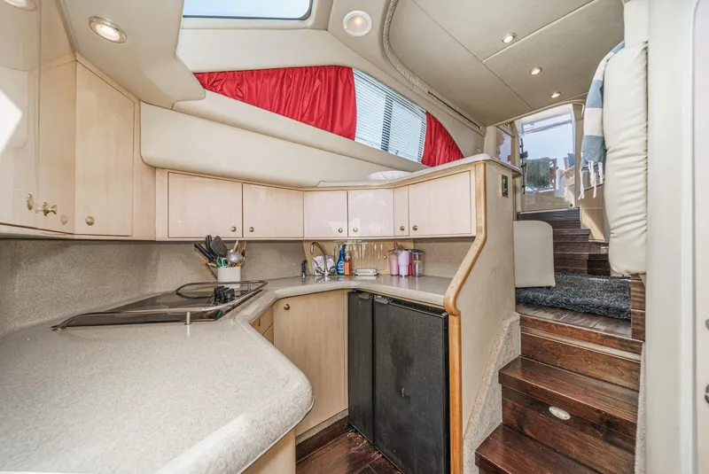 Slide: The Image of Interior of a 1999 Sea Ray 370 Aft Cabin featuring a kitchen and stairs. - 34