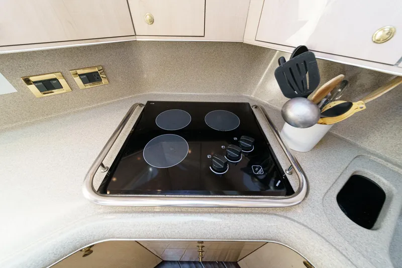 Slide: The Image of The galley of a 1999 Sea Ray 370 Aft Cabin with a built-in cooktop and utensils. - 26