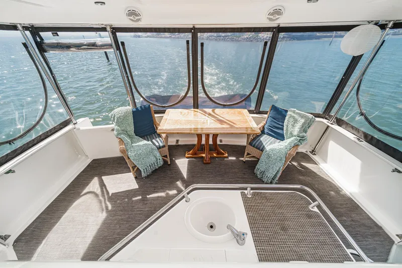 Slide: The Image of A cozy seating area on a boat with two chairs and a table, surrounded by large windows. - 19