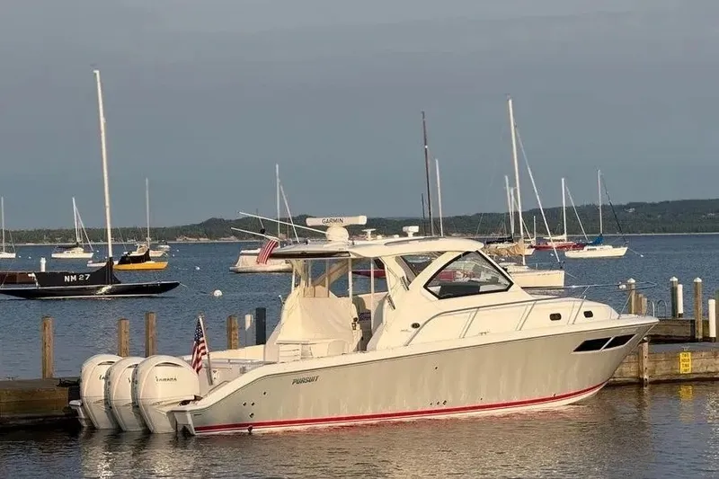 The Image of 2023 Pursuit OS 355 Offshore boat docked at marina with sailboats in background. - 1