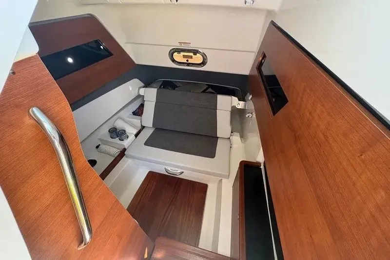 Slide: The Image of 2025 Pursuit S 328 Sport cabin interior with wood accents and seating area. - 23