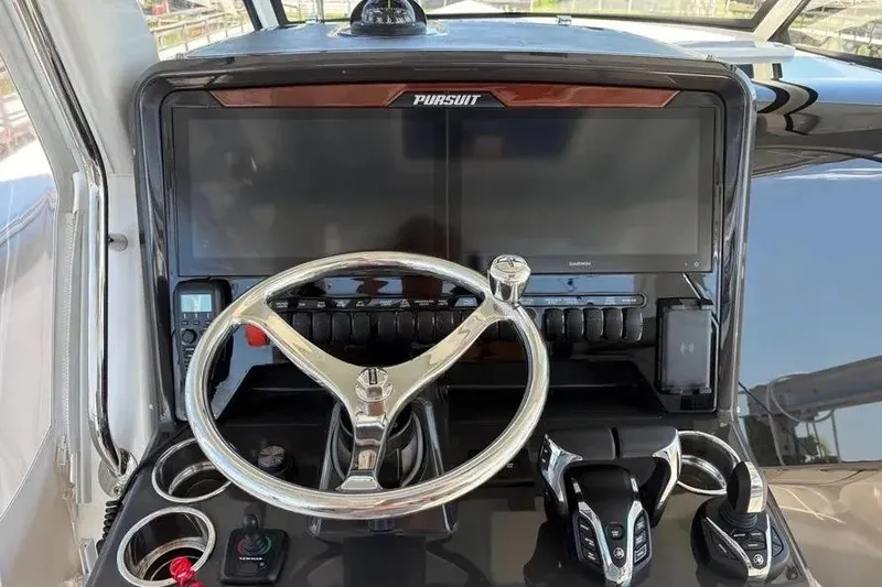 Slide: The Image of Helm of 2025 Pursuit S 328 Sport boat with modern controls and steering wheel. - 15