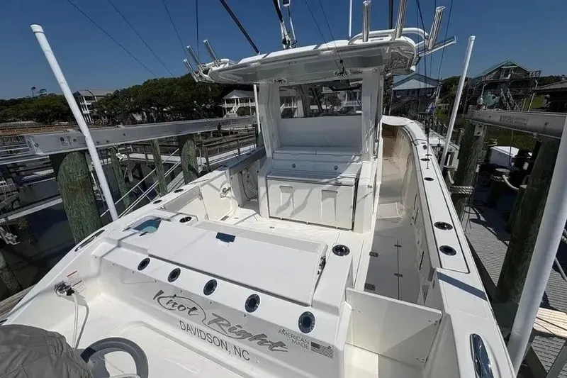 Slide: The Image of 2025 Pursuit S 328 Sport boat docked, showcasing spacious deck and sleek design. - 32