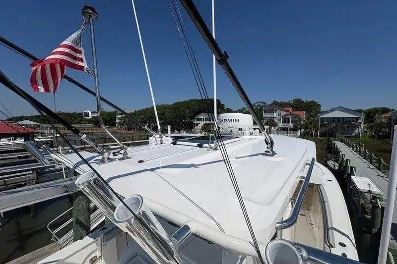 Slide: The Image of 2025 Pursuit S 328 Sport boat docked, featuring American flag and Garmin equipment. - 25