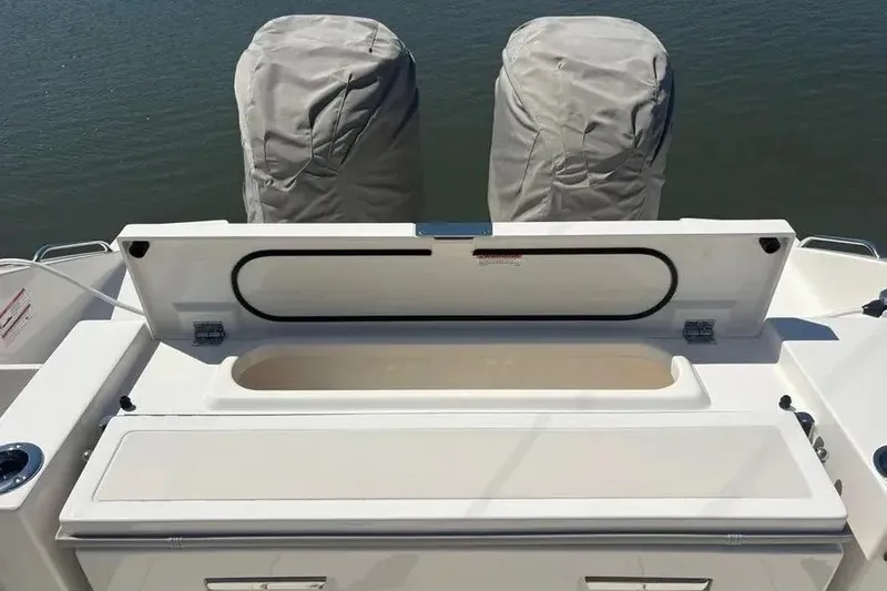Slide: The Image of 2025 Pursuit S 328 Sport boat with covered engines and open storage compartment. - 34