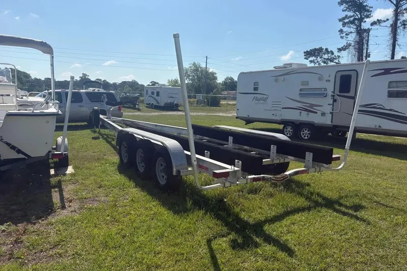 Slide: The Image of Trailer for 2025 Pursuit S 328 Sport boat parked on grassy lot. - 39